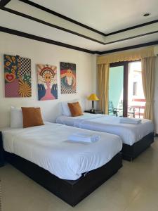 拉迈苏梅岛海风广场酒店的一间带两张床的卧室和一个阳台