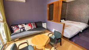 朝仓原鹤温泉 延命馆的小房间配有沙发、桌子和床