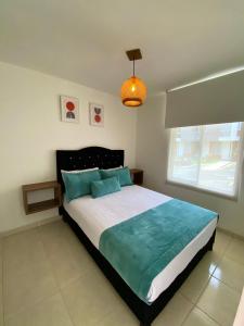 多斯克布拉达斯Apartamento con Piscina en Dosquebradas的一间卧室配有一张带蓝色枕头的大床