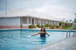 NavgamThe Royal Heritage Tent Resort- Statue of Unity的站在游泳池的水中的女人