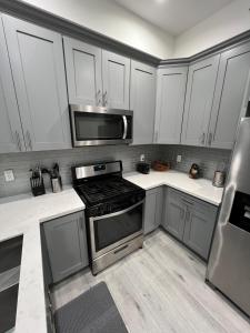 洛杉矶1BR Hollywood Townhouse的厨房配有不锈钢用具和白色橱柜
