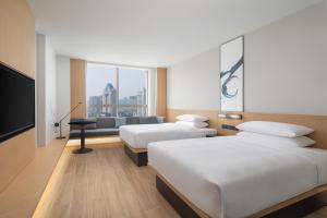 杭州杭州武林广场万枫酒店的酒店客房设有两张床和一台平面电视。