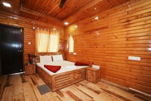 浦那Sunshine Resort的木制客房内的一间卧室,配有一张床