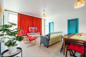 谢赫维蒂利Villa Capri-Kaprovani的客厅配有桌椅和红色窗帘