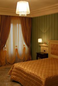 格罗塔米纳尔达里贾纳迪萨巴酒店的一间卧室配有一张床和一个吊灯