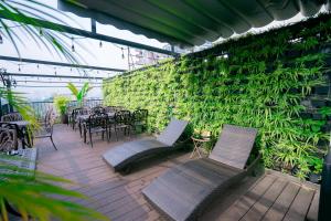 河内22Land Residence Hotel & Spa Ha Noi的一个带桌椅的庭院和绿色的墙壁