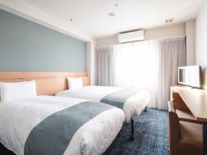 仓敷仓敷船舶酒店的酒店客房设有两张床和电视。