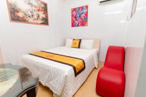 芹苴Motel Hoài An的小房间设有一张床和一把红色椅子