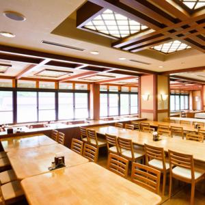 长野Asoviva Nagano Park的餐厅设有木桌、椅子和窗户。