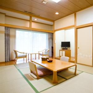 长野Asoviva Nagano Park的客厅配有桌椅和电视。