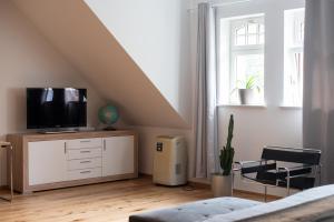 莱比锡Apartment mit Parkblick & Massagestuhl的一间卧室设有带电视的梳妆台和窗户。