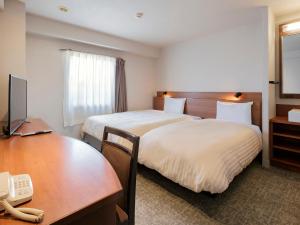 都城市船舶都城酒店的酒店客房配有两张床和一张书桌