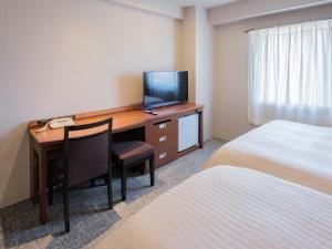 都城市船舶都城酒店的酒店客房配有一张书桌、一台电视和一张床