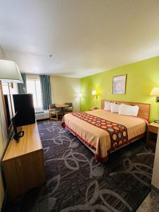 摩押Moab Gateway Inn at Arches Nat'l Park的配有一张床和一台平面电视的酒店客房