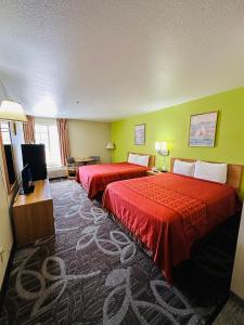 摩押Moab Gateway Inn at Arches Nat'l Park的酒店客房设有两张床和一台平面电视。