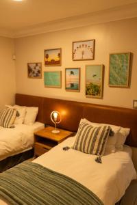 LangstrandDeja Blue Beachfront Villa的一间卧室配有两张床和一张带台灯的桌子