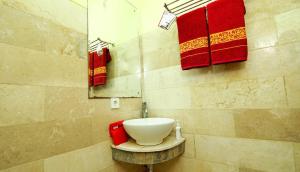 勒吉安The Legian 777的浴室设有白色水槽和红色毛巾。