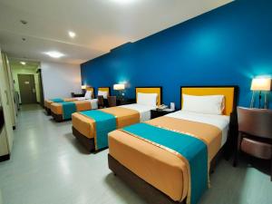 马尼拉Studio 89 Katipunan QC的一间设有三张床和蓝色墙壁的房间