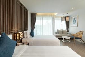 奈扬海滩Bella Nara Phuket Naiyang Beach的酒店客房,设有两张床和一张沙发