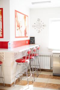 波兹南利欧旅舍的厨房在白色柜台上设有红色凳子