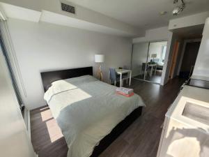 多伦多Toronto Premier INN的一间卧室配有一张大床和一张桌子