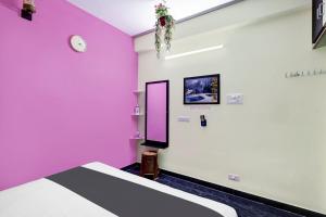 蒂鲁帕蒂OYO SS Home Stay - An Unique Home Stay的一间设有粉色和白色墙壁和床的房间