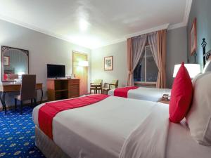富查伊拉City Plaza Hotel的酒店客房配有两张床和一张书桌