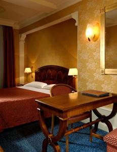 博洛尼亚欧若罗吉奥艺术酒店的配有一张床、一张桌子和一张桌子的酒店客房