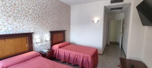 阿特佛艾尔顿赛尔酒店的一间设有两张粉红色床单的床的房间