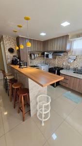 阿奎拉兹Apartamento Confortável - Porto das Dunas - Perto do Beach Park的厨房配有带凳子的木台
