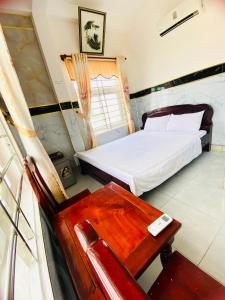 惹岛Hoa Bien Motel的一间卧室配有一张床、一把椅子和一张书桌