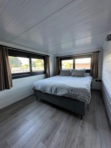 博德鲁姆Gaia Tiny Houses Butik Hotel的拖车内的卧室,配有床和2扇窗户