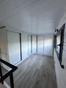 博德鲁姆Gaia Tiny Houses Butik Hotel的空空房间,设有白色的墙壁和木地板