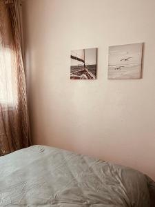 拉罗谢尔chez Jin Jin的卧室配有两张墙上的照片和一张床