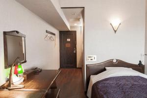 冈崎市冈崎大和酒店的一间卧室配有一张床和一张带镜子的书桌