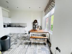 巴里Leah Suite by Koya Homes的厨房配有白色橱柜和木桌