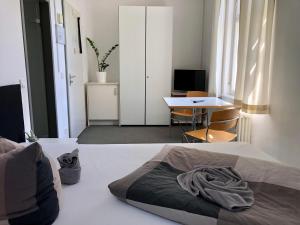 萨勒河畔哈雷Ferienwohnungen und Apartmenthaus Halle Saale - Villa Mathilda的一间卧室配有一张床、一张桌子和一张书桌