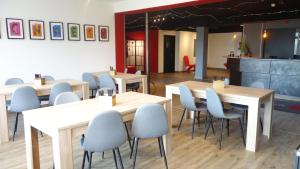 布伦瑞克Plaza Inn Braunschweig City Nord的餐厅设有木桌和蓝色椅子