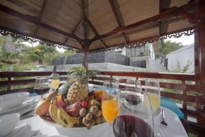 曾蒙海滩超豪华皇家泰式别墅的一张桌子,上面放着一碗水果和一杯葡萄酒