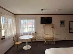 林肯港Shaen Street Motel的配有桌椅和电视的客房