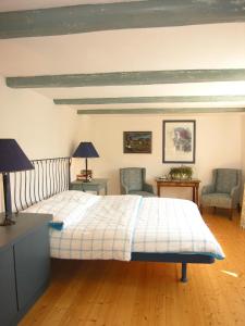 PapstdorfApartmenthaus Brunnenhof的一间卧室配有一张带两把椅子和两盏灯的床。