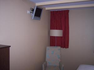 BredevoortHotel Bertram的客房设有椅子和带电视的窗户。