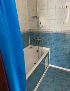 LalovoHotel Zoloti Vorota的浴室配有蓝色和白色瓷砖的浴缸