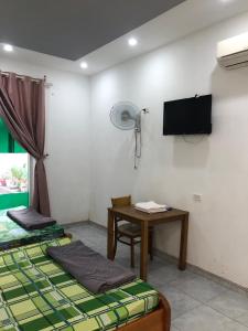 Chơn ThànhNhà Nghỉ Minh Thảo的客房设有两张床、一张桌子和风扇。