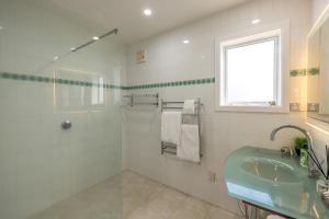 棕榈滩2 Levels of Magnificient Sea Views的白色的浴室设有水槽和窗户。