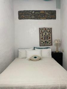 帕斯蒂达Philoxenia traditional house的卧室配有白色的床和帽子