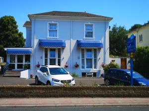 托基和谐住宿加早餐旅馆的停在蓝色房子前面的白色汽车