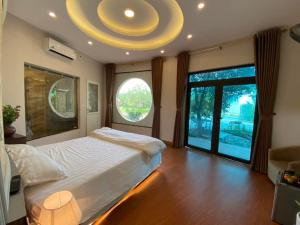 Lương SơnBiển Đông COMPLEX的一间卧室设有一张大床和一个大窗户