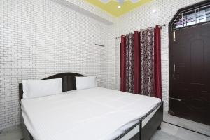 鲁尔基SPOT ON Hotel Doon Sabri的一张位于一间黑门和红色窗帘的房间的床铺