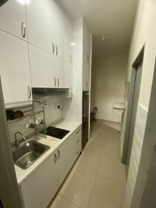 吉隆坡Ayuman Suites, 1 Bedroom with KL View的厨房配有白色橱柜和水槽